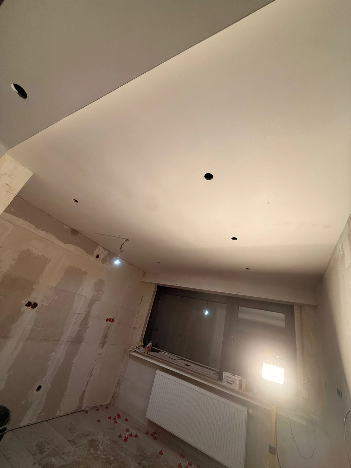 Spanndecken Grunau - Sanierung, Renovierung & Innenausbau - Schräge Ansicht einer Decke mit frisch verspachtelten Gipskartonfugen und runden Einbauleuchten.