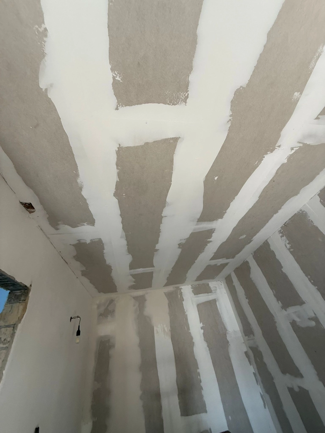Spanndecken Grunau - Sanierung, Renovierung & Innenausbau - Nahaufnahme einer Decke mit dicken Fugenmassen zwischen den Gipskartonplatten.