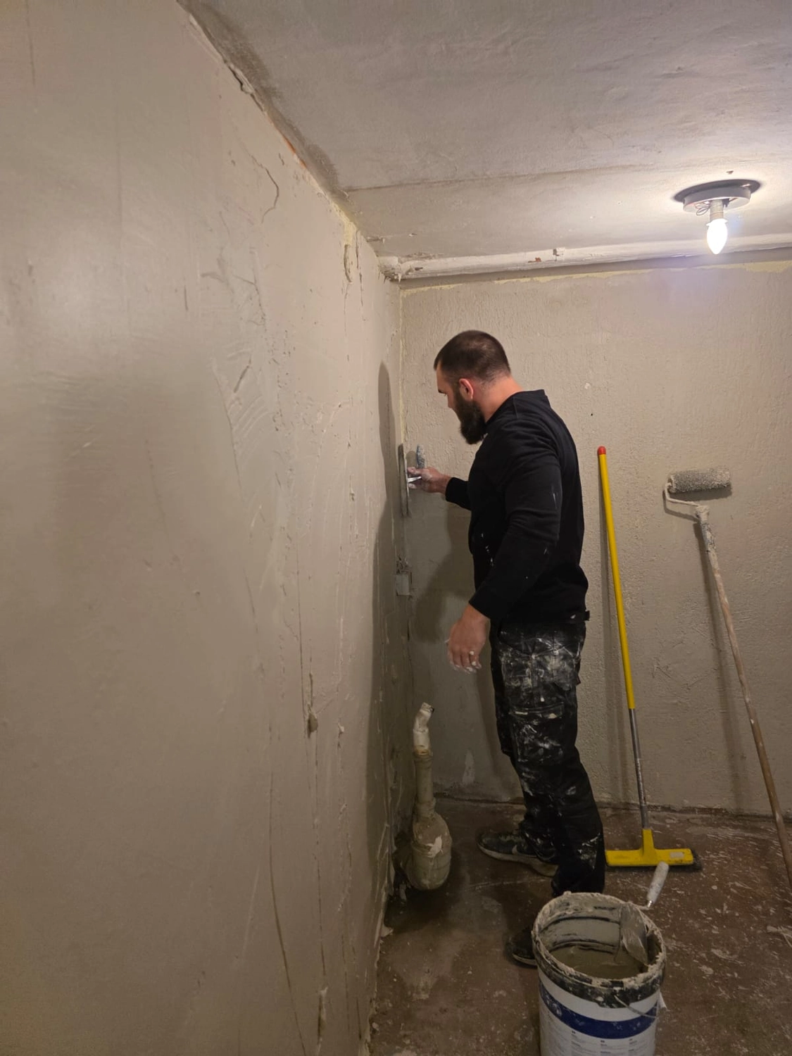 Spanndecken Grunau - Sanierung, Renovierung & Innenausbau - Ein Mann, der während der Bauarbeiten Gips oder Gipskartonspachtelmasse an eine Innenwand eines Raumes aufträgt.