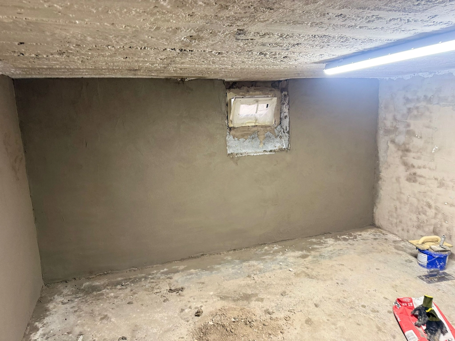 Spanndecken Grunau - Sanierung, Renovierung & Innenausbau - Frisch verputzte, glatte, graue Wand im Keller.
