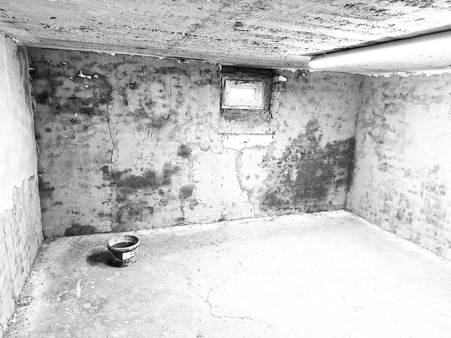 Spanndecken Grunau - Sanierung, Renovierung & Innenausbau - Schwarz-Weiß-Aufnahme einer strukturierten Betonwand im Keller.
