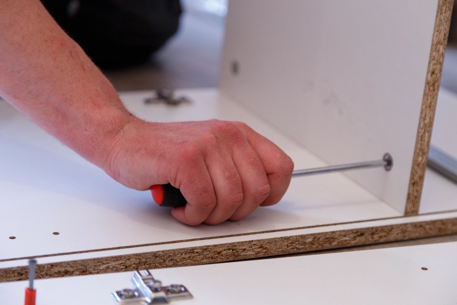 Spanndecken Grunau - Sanierung, Renovierung & Innenausbau - Hand montiert mit einem Schraubenzieher weiße Holzmöbelpaneele.